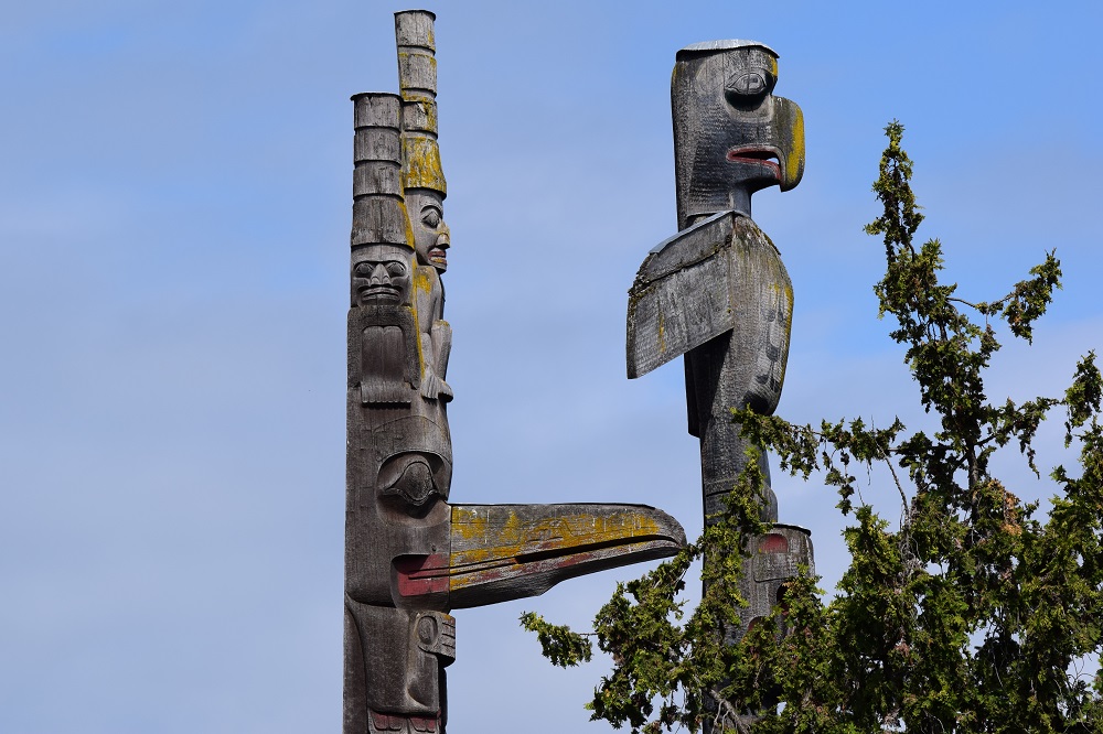 Two of several traditionally carved totem poles on display at Thunderbird Park in Victoria BC